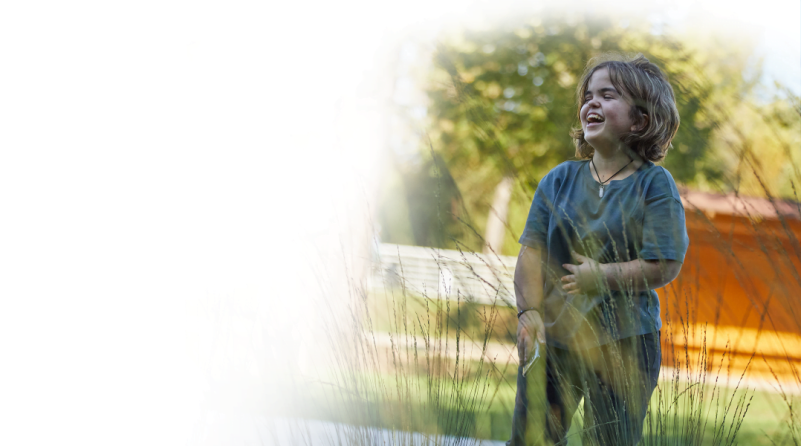 a young girl with Achondroplasia laughing while wearing a crystal necklace											