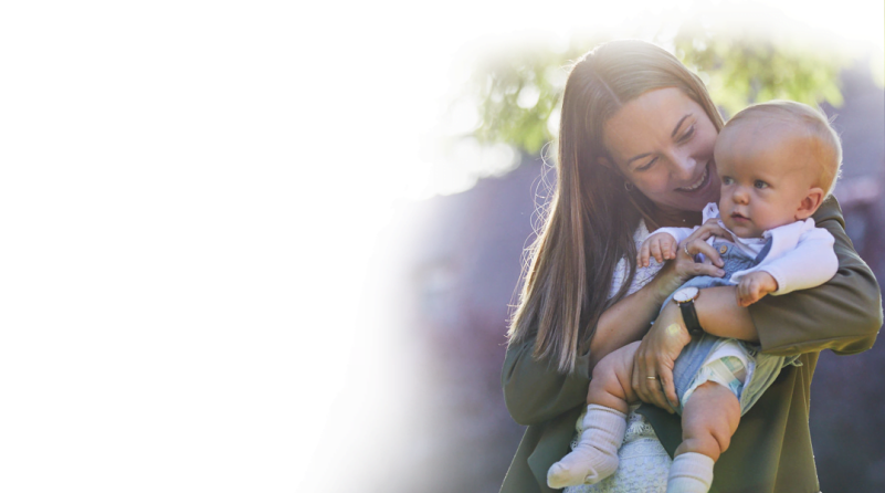 a woman with long hair holding a baby boy with Achondroplasia											