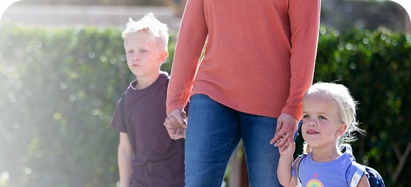 a mother holds the hand of her young daughter who has Achondroplasia and her son