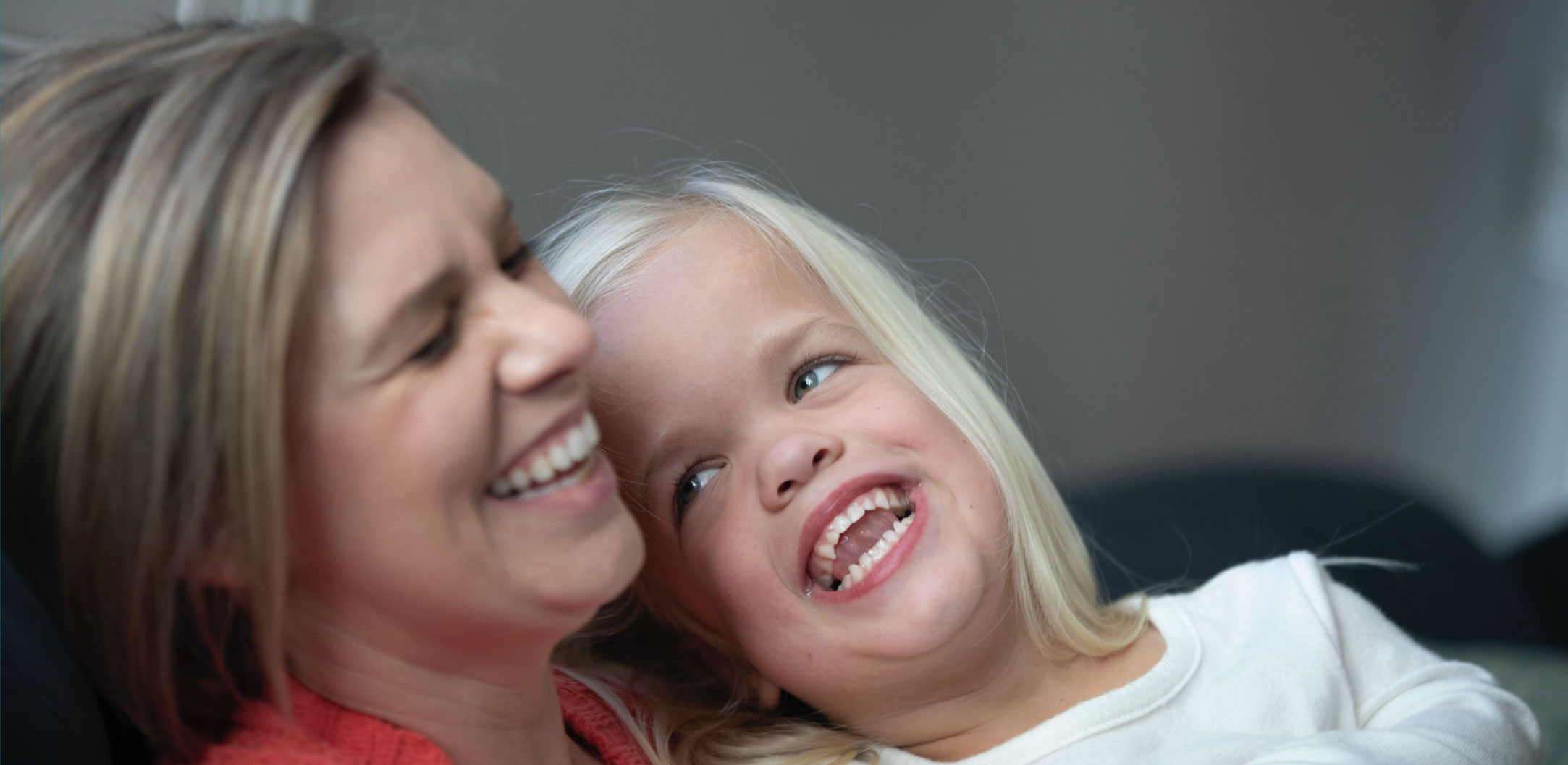 a girl with Achondroplasia laughing with her mom