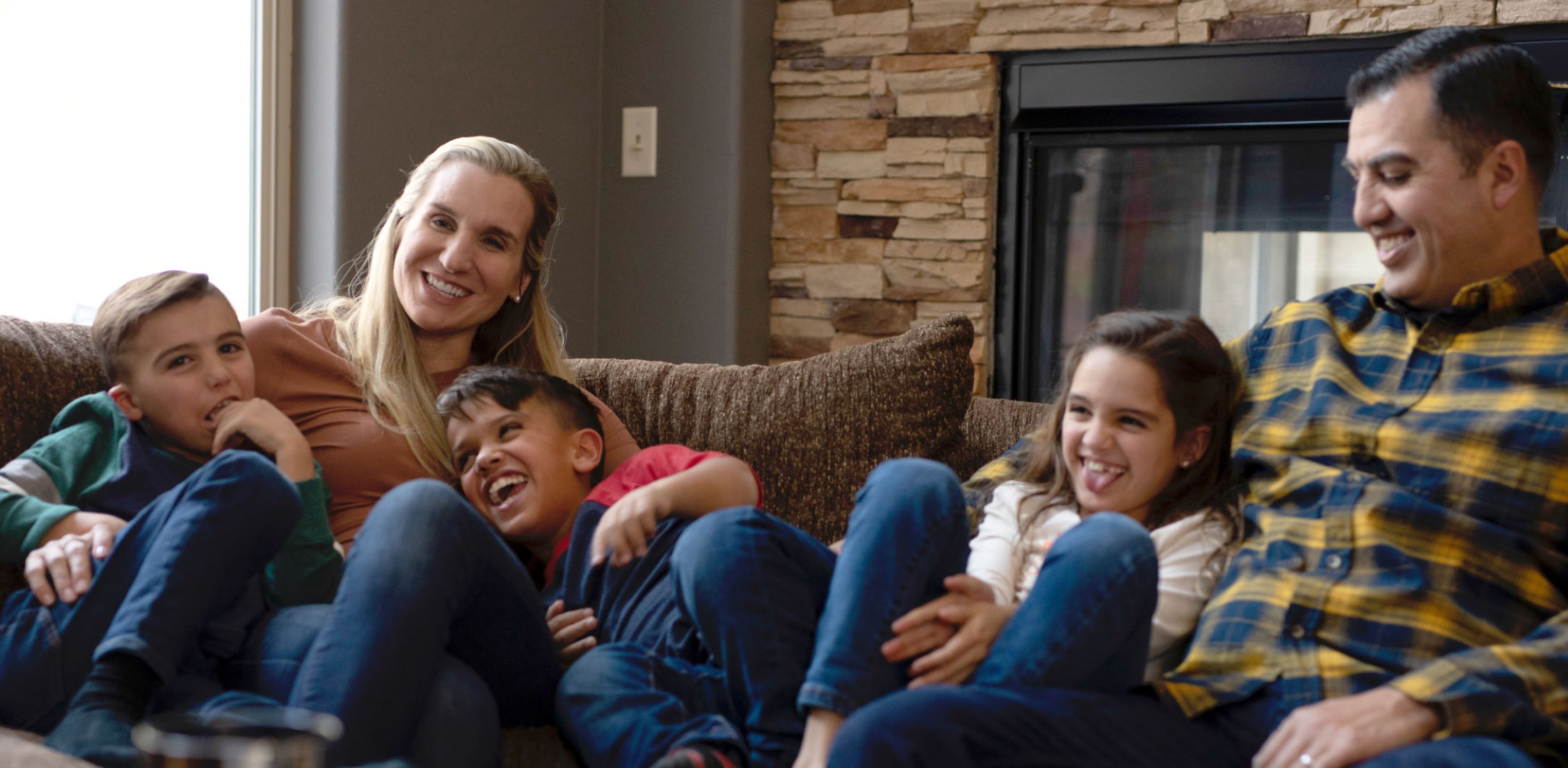 a child with achondroplasia enjoying time with his family on the sofa