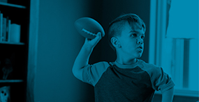 a boy with Achondroplasia, a type of dwarfism, throwing a football