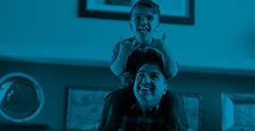 a boy with skeletal dysplasia sits on his fathers shoulders