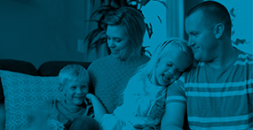 a young girl with skeletal dysplasia sits with her family on the couch