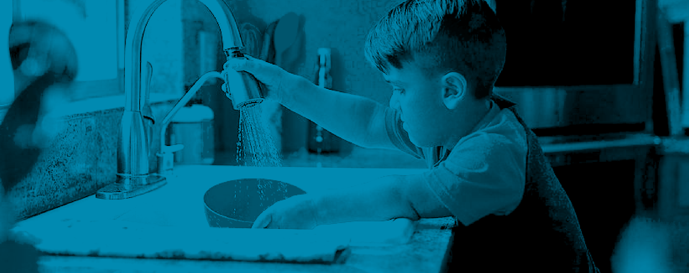 a boy with Achondroplasia washing a bowl in the kitchen sink